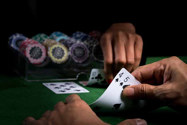 Ruka koja drži tarx prikazuje nominalne vrijednosti nad protivnikom, a zatim igra blackjack na zelenom stolu i mutnoj pozadini naslaganih žetona u kasinu